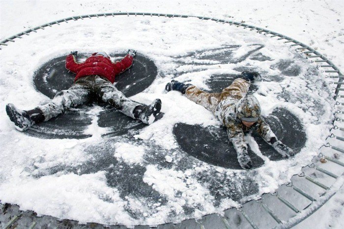 Jouer sur un trampoline dans la neige en hiver