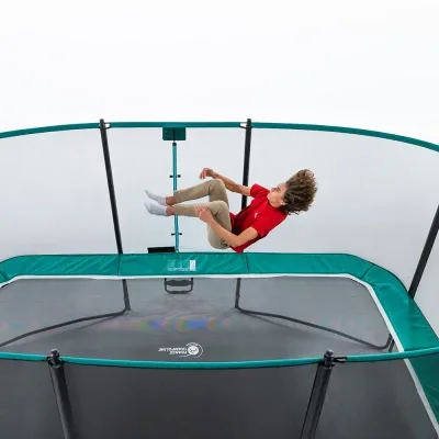 Enfant en plein saut sur un trampoline de jardin
